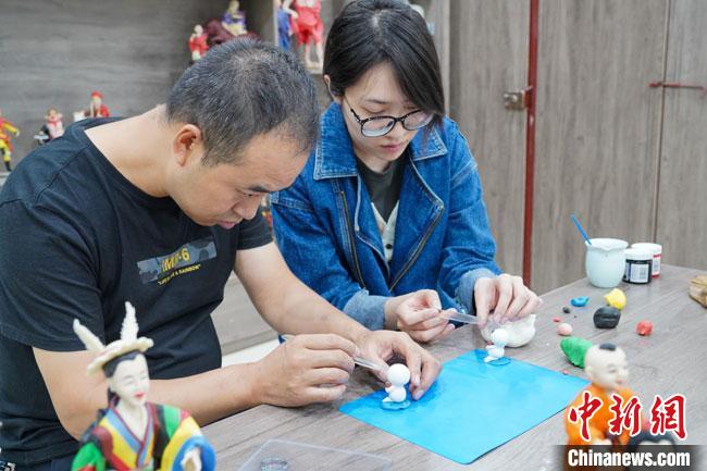 <a target='_blank'  data-cke-saved- >中新社</a>記者(右)現(xiàn)場體驗面塑制作過程?！￡悹帍?攝