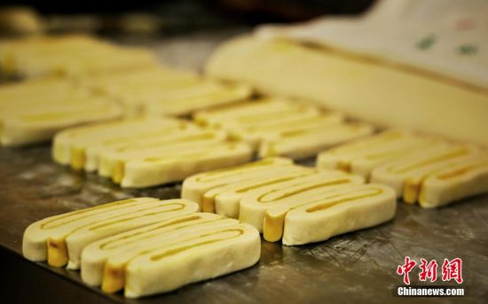 圖為面劑被涂上胡麻油，切成條狀用作月餅的花型制作。張文 攝