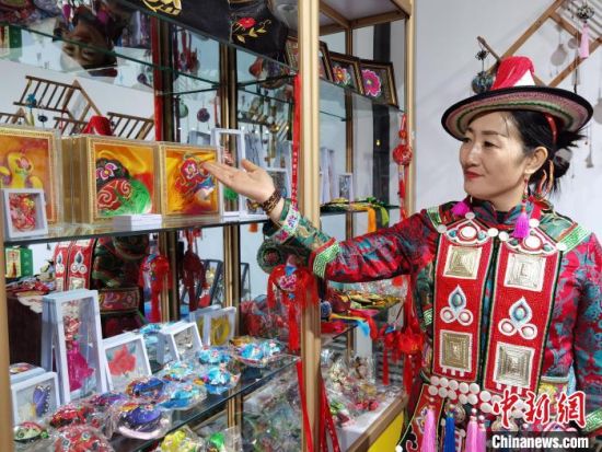 圖為身著民族服飾的隴原巧手展示手工藝品。(資料圖) 徐雪 攝
