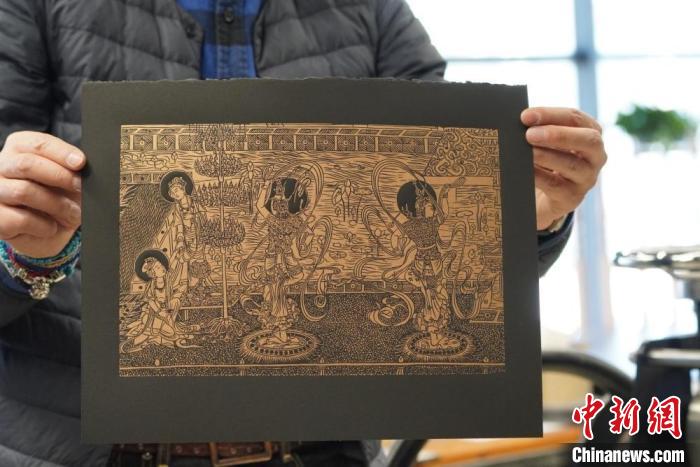 圖為手工書藝人展示敦煌雕版壁畫印刷品。　九美旦增 　攝