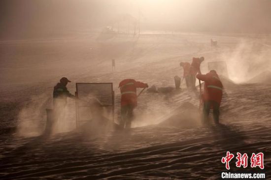 圖為敦煌市鳴沙山月牙泉景區(qū)“駱駝保姆”清理駱駝糞便?！垥粤?攝