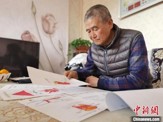 圖為陸鵬飛向記者展示多年帶隊(duì)的手寫(xiě)筆記?！堟?攝