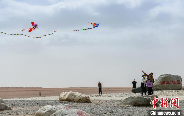 圖為市民正在陽關(guān)景區(qū)放風(fēng)箏。　王斌銀 攝