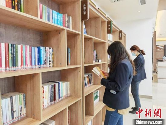 圖為在甘肅公航旅建設集團有限公司的職工書屋，職工挑選書籍。　徐雪 攝