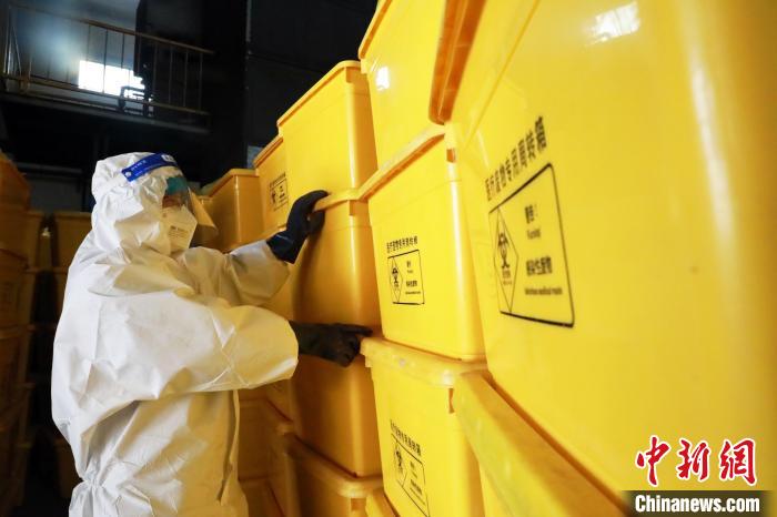 圖為工作人員搬運醫(yī)療廢物專用周轉(zhuǎn)箱。　魏建軍 攝