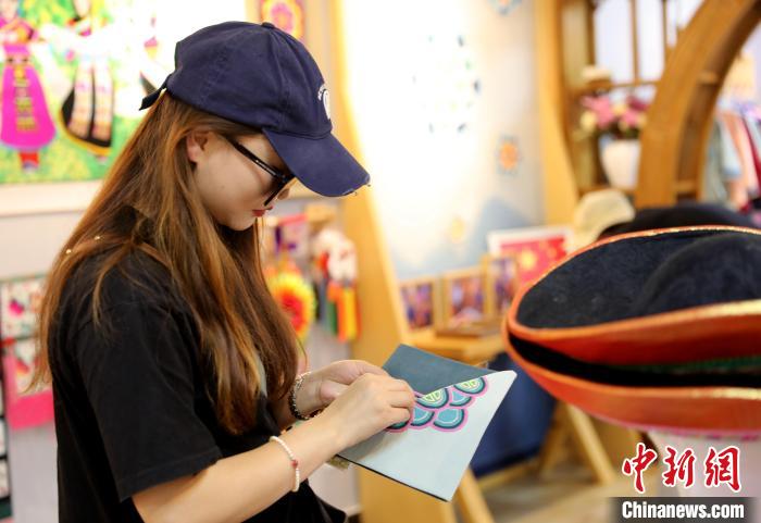 圖為民眾體驗(yàn)國(guó)家級(jí)非遺項(xiàng)目盤(pán)繡技藝?！⊙Φ?攝