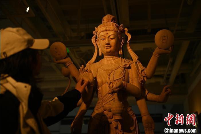 圖為季茂杰觀察自己創(chuàng)作的敦煌木雕。李亞龍 攝</p>
<p>