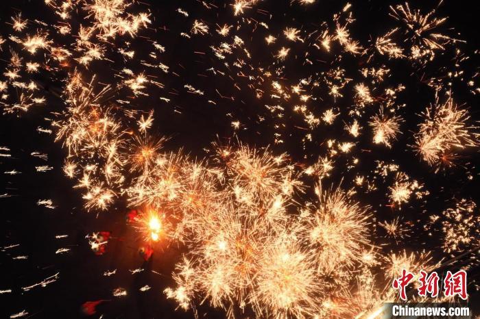 灼熱的鐵水在空中迸散。在空中形成“鐵花火雨”的景象，似天女散花，似群星漫天，如夢如幻，美不勝收。侯奇志 攝</p>
<p>