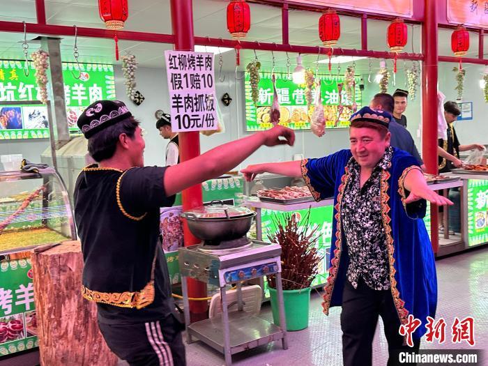 圖為餐飲經(jīng)營(yíng)者在“西涼不夜城”跳起舞蹈引客?！〈魑牟?攝</p><p>