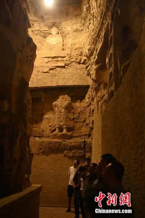 7月15日，游人參觀甘肅省平?jīng)鍪袥艽h百里石窟長廊中的王母宮石窟。百里石窟長廊位于涇川縣境內(nèi)，由512個石窟、5眼窟中石井組成，現(xiàn)存王母宮石窟、鳳凰山石窟、南石窟寺、丈八寺石窟、羅漢洞石窟、太山寺石窟等規(guī)模較大的石窟群，還有數(shù)量眾多的小石窟群。王母宮石窟又名千佛洞，該窟設(shè)計宏大，造像生動，窟內(nèi)擁有造像數(shù)百尊，是較為珍貴的佛教文化遺存。中新社記者 李亞龍 攝</p>
<p>